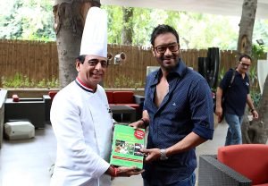 Chef Davinder Kumar presented set of culinary books to Bollywood star Mr. Ajay Devgn.